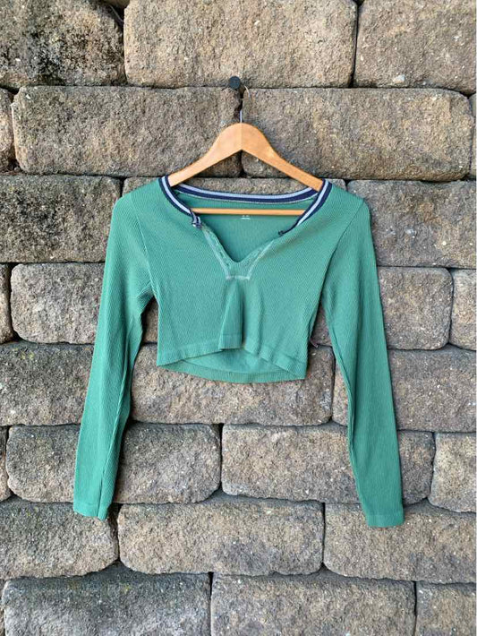 Green cropped long-sleeve henley shirt with buttoned neckline, soft lightweight fabric.