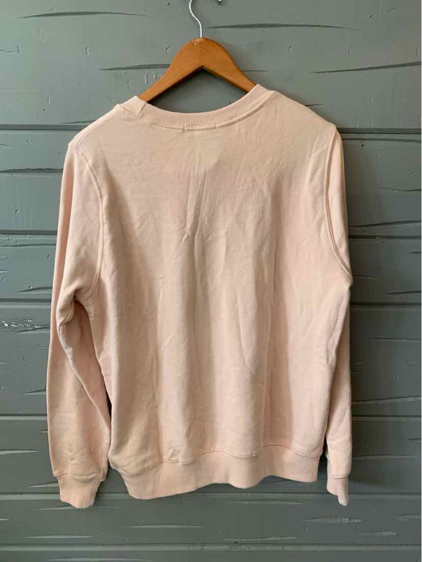 Light pink long-sleeve sweatshirt with ribbed cuffs and hem, soft knit fabric, crew neckline.