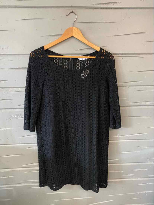 Black lace knee-length dress with three-quarter sleeves and rounded neckline on wooden hanger.
