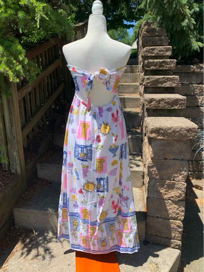 White strapless maxi dress with colorful abstract patterns and a bow detail at the back.
