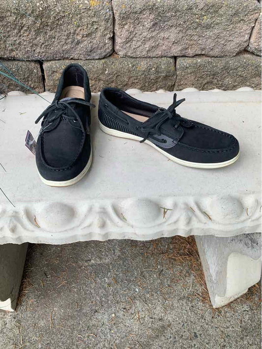 Black casual boat shoes with white soles, lace-up front, and textured fabric upper.