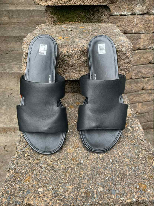 Black slip-on sandals with wide leather straps and cushioned footbeds, size 9, flat soles.