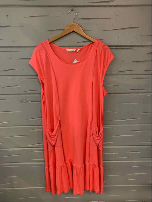 Coral short-sleeve dress with scoop neckline, gathered side pockets, and ruffled hem.