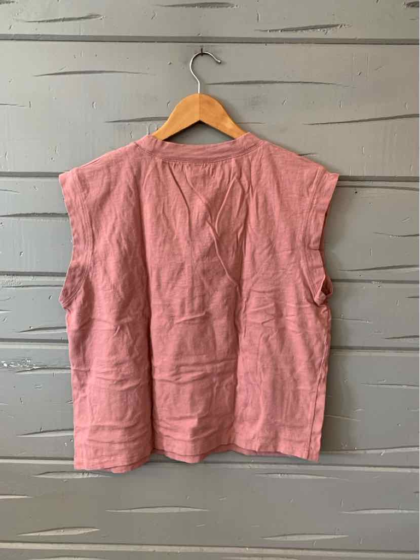 Sleeveless mauve cotton top with boxy fit and wide armholes hanging on wooden hanger.
