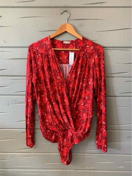 Red floral long-sleeve Free People wrap top with a deep V-neck and tied front hem.