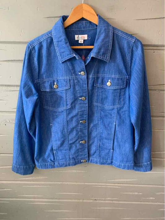 Classic blue denim jacket with button front, two chest pockets, and long sleeves on wooden hanger.