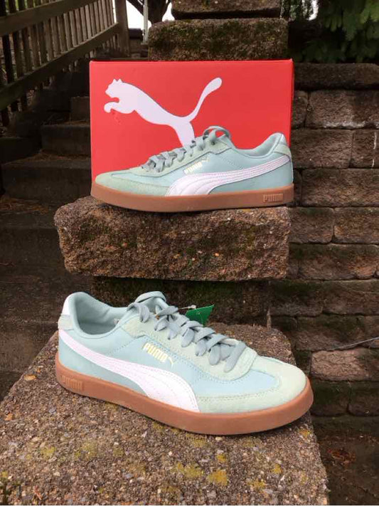 Light blue Puma sneakers with white side stripe and gum sole, size 8, displayed outdoors with red Puma box.