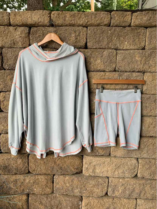 Light blue long-sleeve hoodie and matching shorts with coral stitching, soft fabric activewear set.