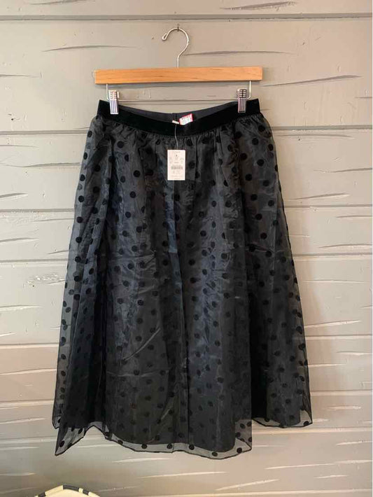 Black midi skirt with polka dot mesh overlay, A-line silhouette, and waistband detail.