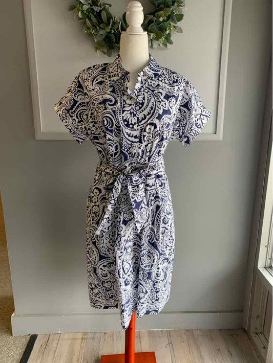 Navy and white paisley print shirt dress with short sleeves and a tie waist on mannequin.