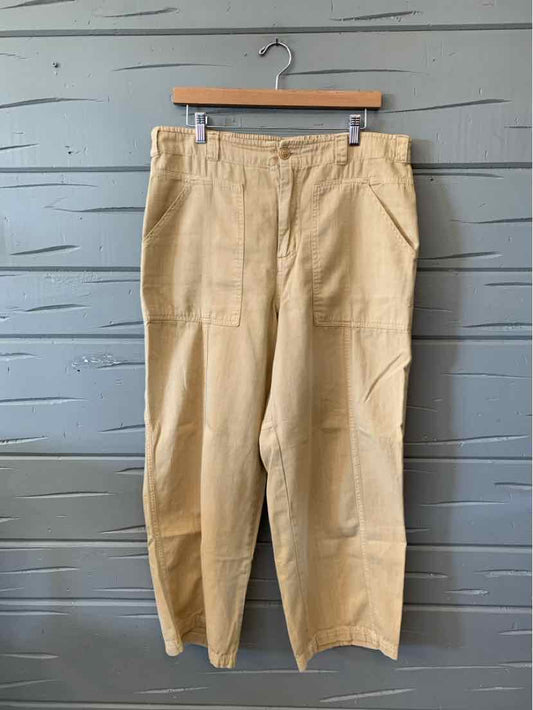 Tan women’s straight-leg pants with a button fly, belt loops, and front pockets, hanging on a hanger.