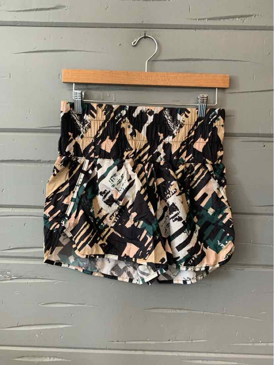High-waist shorts with abstract black, tan, and teal brushstroke print, elastic waistband, and loose fit.