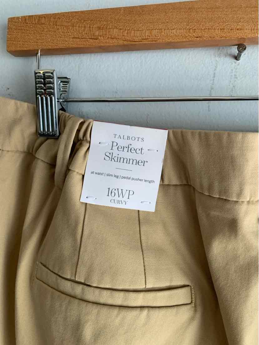 Tan tailored pants with back welt pocket and labeled tag hanging on wooden hanger.