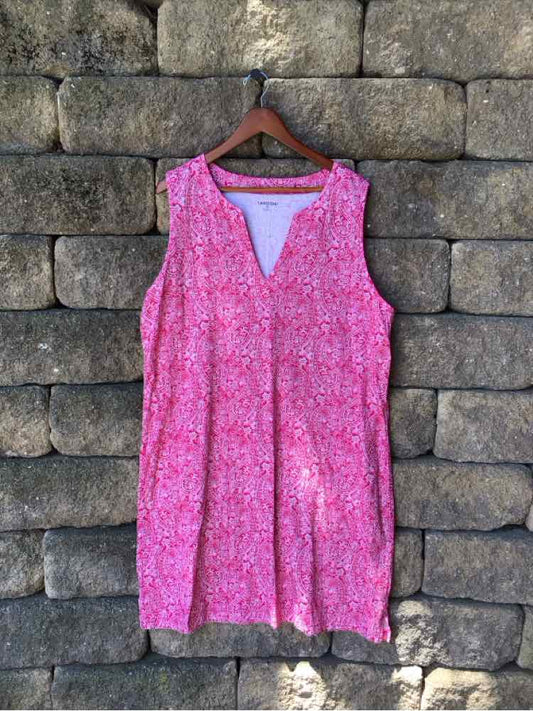 Sleeveless pink paisley print dress with V-neck and relaxed fit, hanging on wooden hanger.