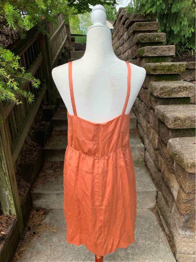 Orange silk sleeveless dress with thin straps and gathered waist, size 8, displayed on mannequin outdoors.