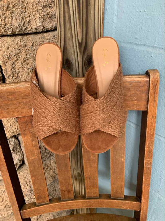 Brown woven open-toe slide sandals with flat soles and slip-on design.