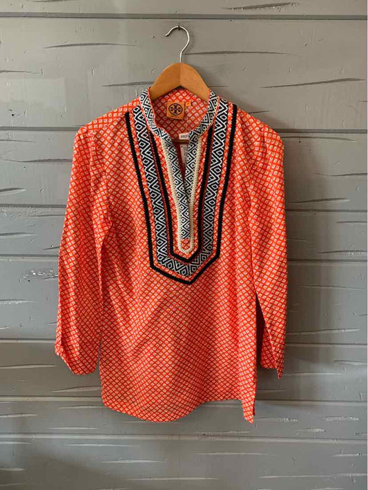 Orange long-sleeve blouse with white geometric pattern and multicolor striped bib neckline.