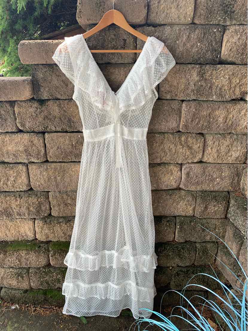 White lightweight maxi dress with deep V-neck, short flutter sleeves, and tiered ruffle hem.