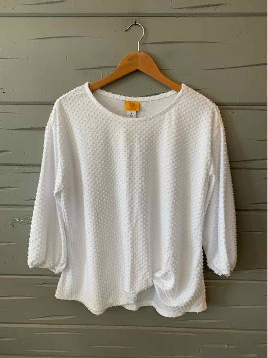 White textured long-sleeve blouse with rounded neckline and relaxed fit on wooden hanger.