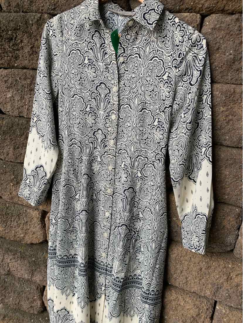 Long-sleeve button-up shirt in gray with intricate black and white paisley pattern and white cuffs with small black designs.