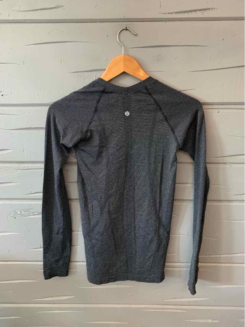 Long-sleeve fitted metallic dark gray athletic top with raglan sleeves and reflective logo on upper back.