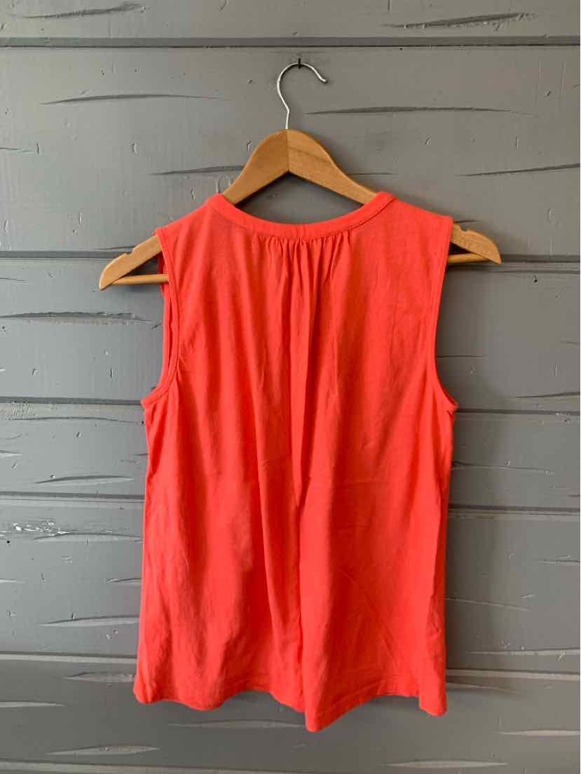Sleeveless coral tank top with round neckline and relaxed fit on wooden hanger.