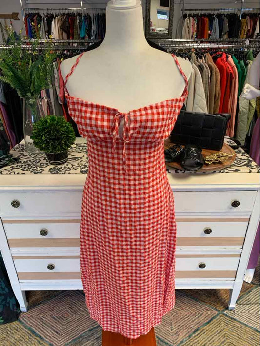 Red and white gingham sleeveless dress with thin straps and front button detail on mannequin.