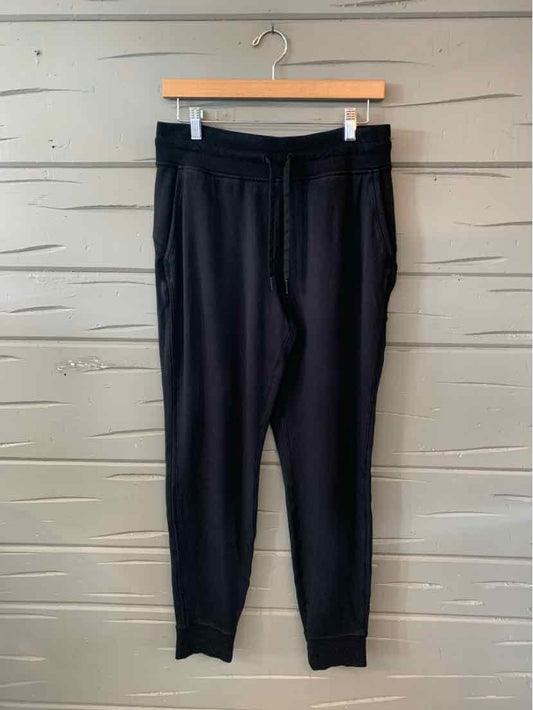 Black tapered jogger pants with elastic waistband and cuffed ankles, size 8.