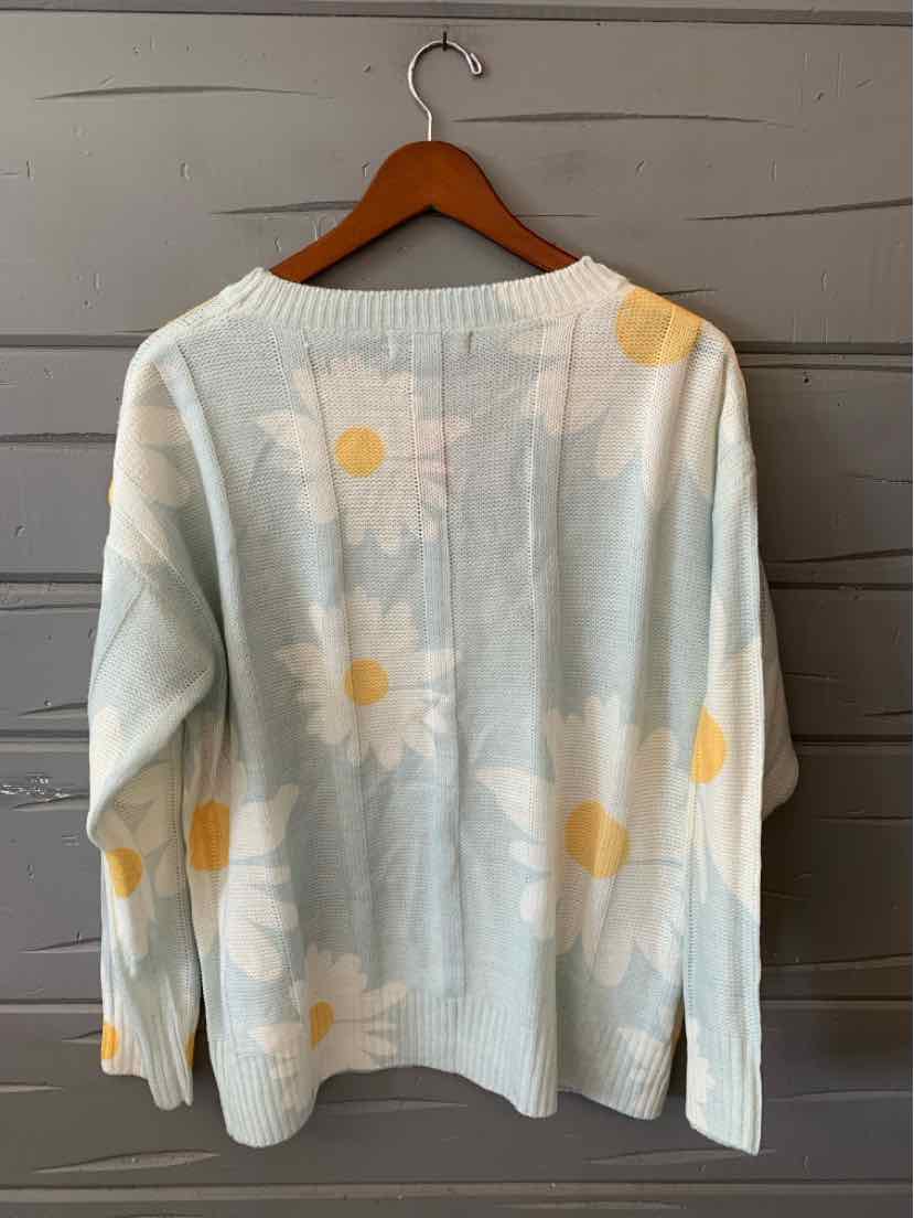Light blue knit sweater with large white daisies and yellow centers, long sleeves, relaxed fit.