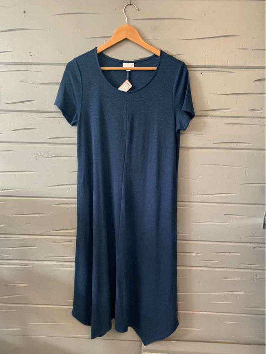 Navy blue short-sleeve knit dress with scoop neck and relaxed fit hanging on wooden hanger.