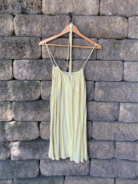 Light yellow gingham slip dress with thin spaghetti straps and a relaxed fit hanging on wooden hanger.