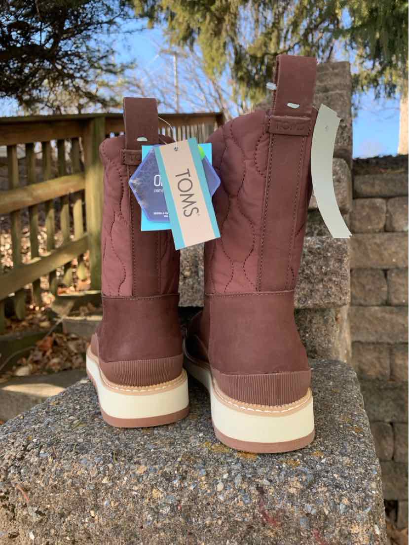 Brown leather TOMS women's boots size 9 with beige soles and branded tags hanging from pull tabs.