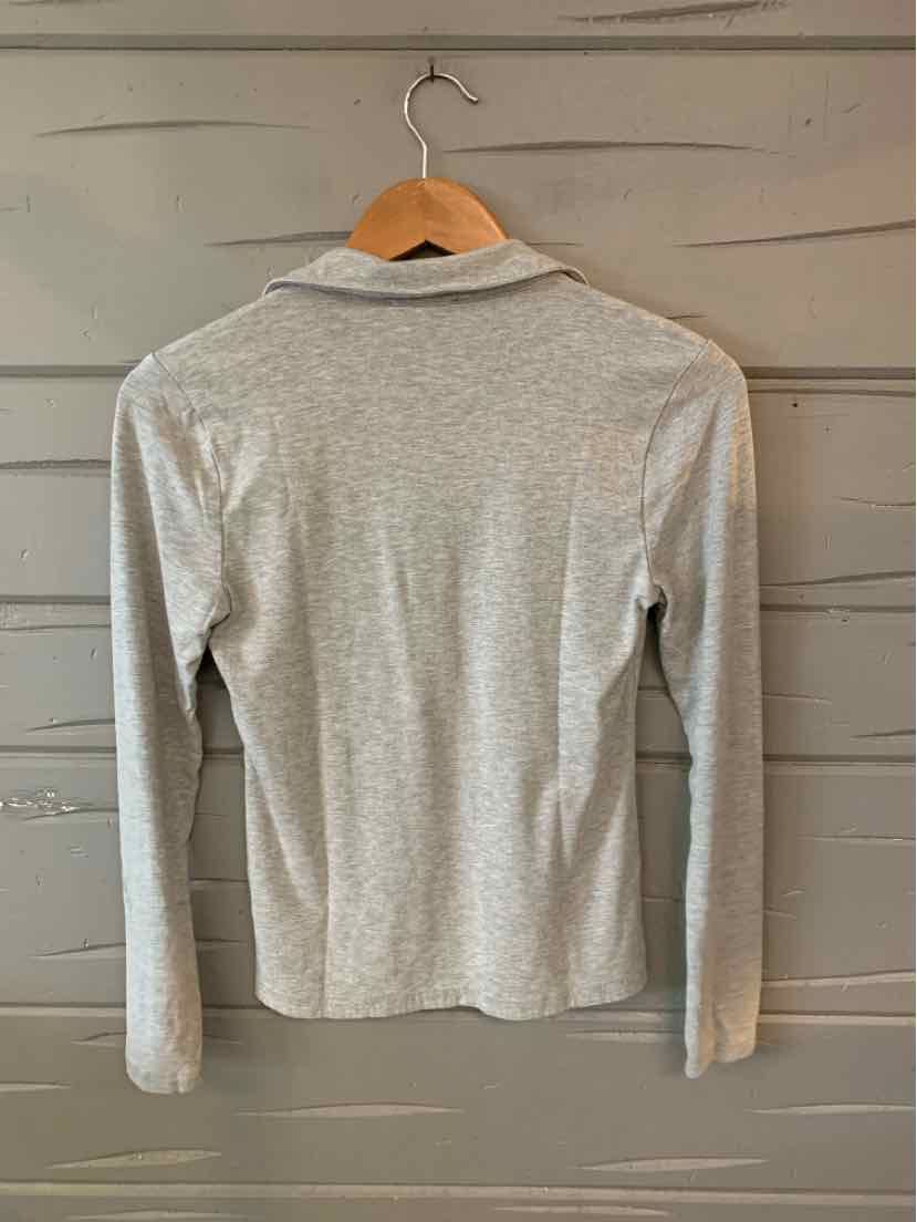 Light gray long-sleeve crew neck top with fitted silhouette hanging on wooden hanger.
