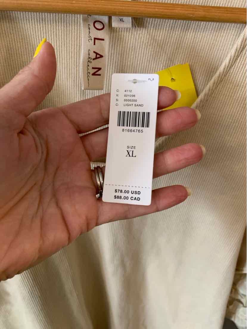 Tan fabric with a smooth texture hanging on a wooden hanger with a white size XL price tag attached.