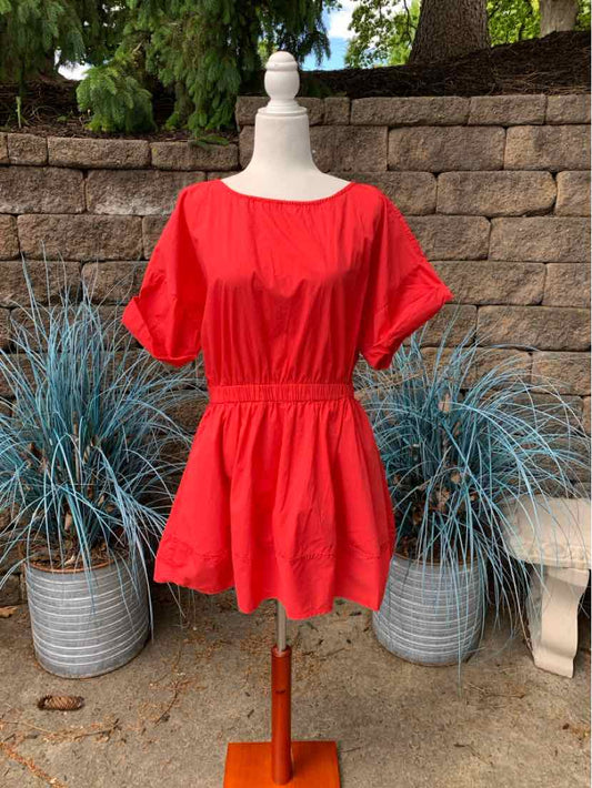 Red short-sleeve dress with cinched waist and round neckline on mannequin outdoors.