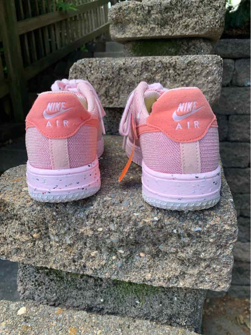 Pink Nike Air sneakers with white soles and speckled midsole, size 8.5, viewed from the back.