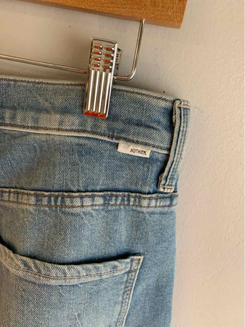 Light blue denim jeans with white MOTHER label on waistband, size 4, folded at hanger clip.