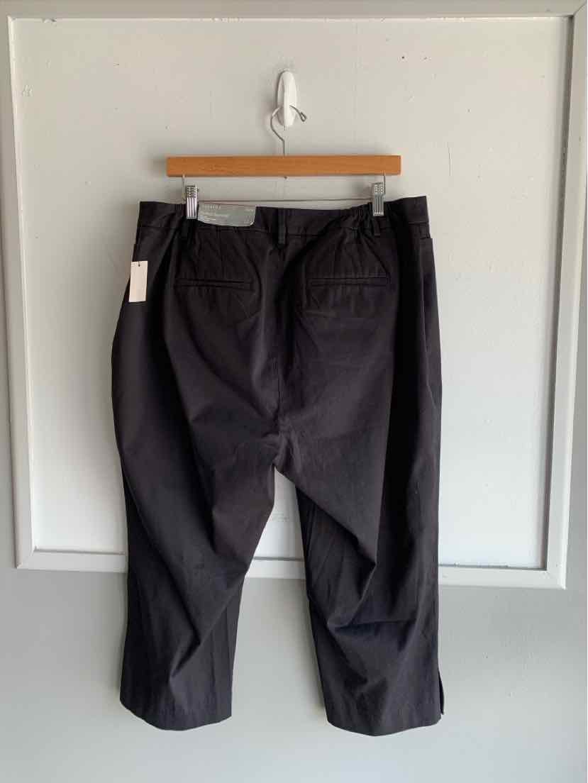 Black wide-leg pants in size 14W with back pockets hanging on wooden hanger.