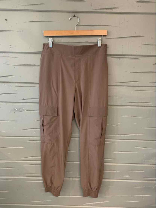 Brown high-waist jogger pants with elastic cuffs and side cargo pockets.