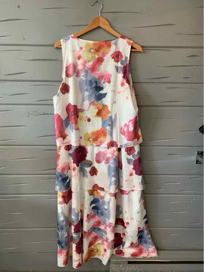 Sleeveless white dress with large pink, red, and blue floral print, loose fit, midi length.