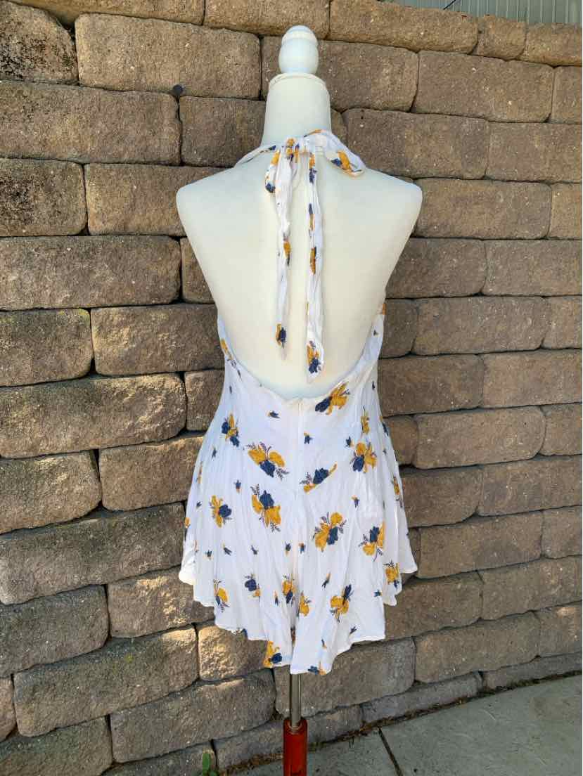White halter dress with yellow and black floral print, open back, and flowy skirt.