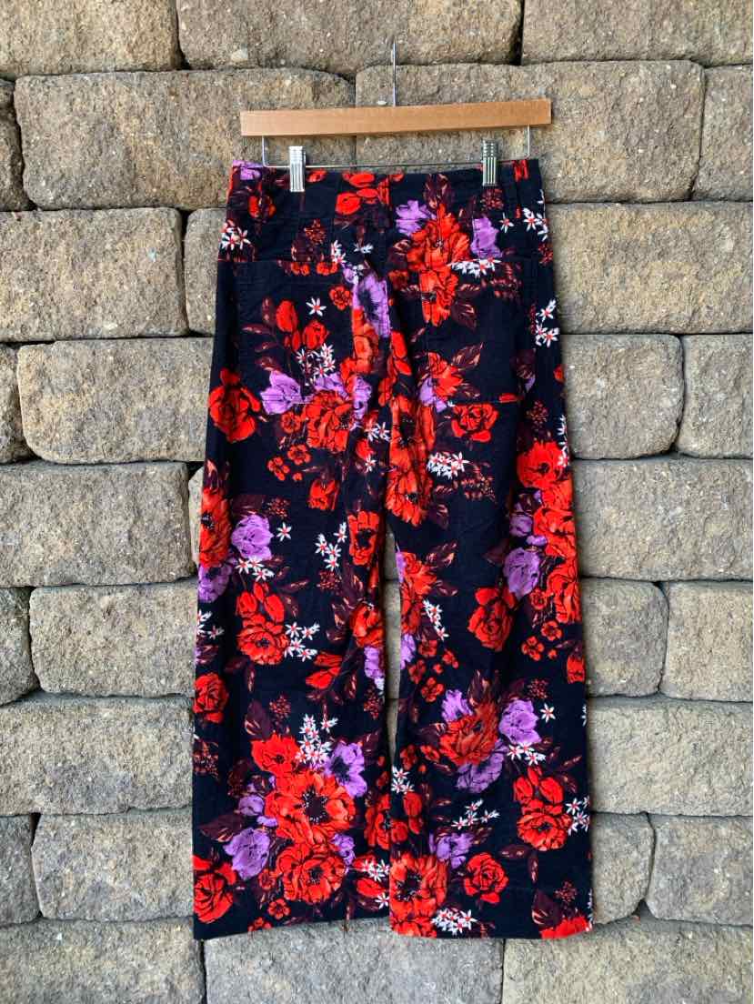 Wide-leg pants with black base and vibrant red, purple, and pink floral print.