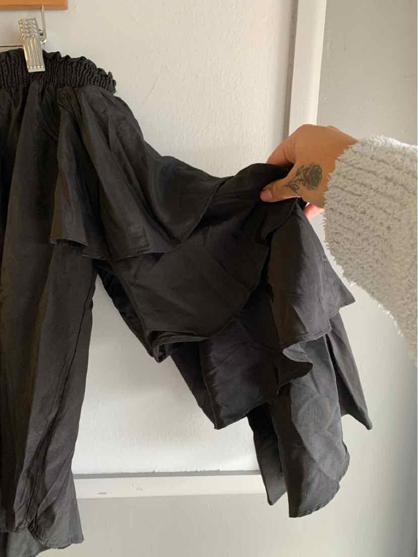 Black lightweight layered skirt with ruffled asymmetrical hem and elastic waistband.