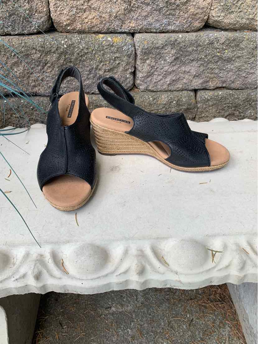 Black open-toe wedge sandals with slingback strap and light tan woven platform sole.