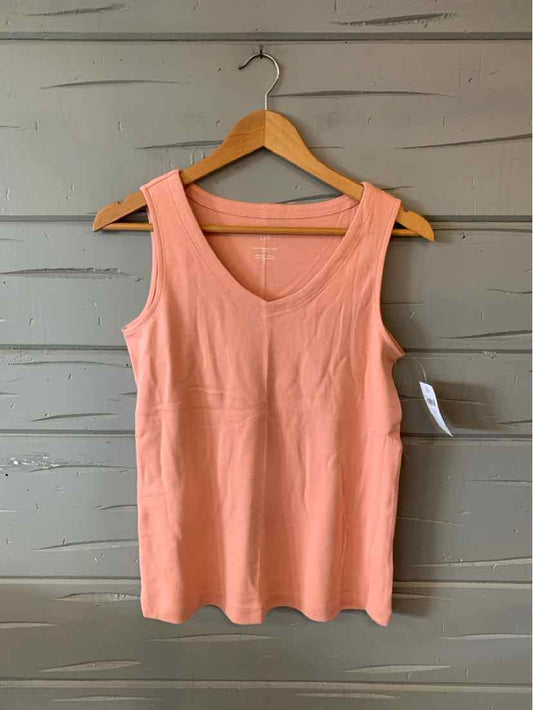 Sleeveless soft pink cotton tank top with round neckline hanging on wooden hanger.