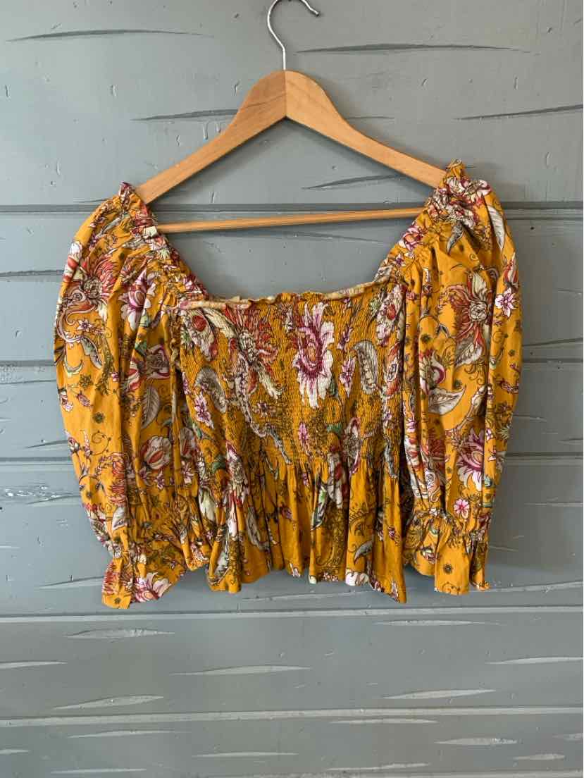 Yellow floral off-shoulder crop top with puff sleeves and smocked waist on wooden hanger.