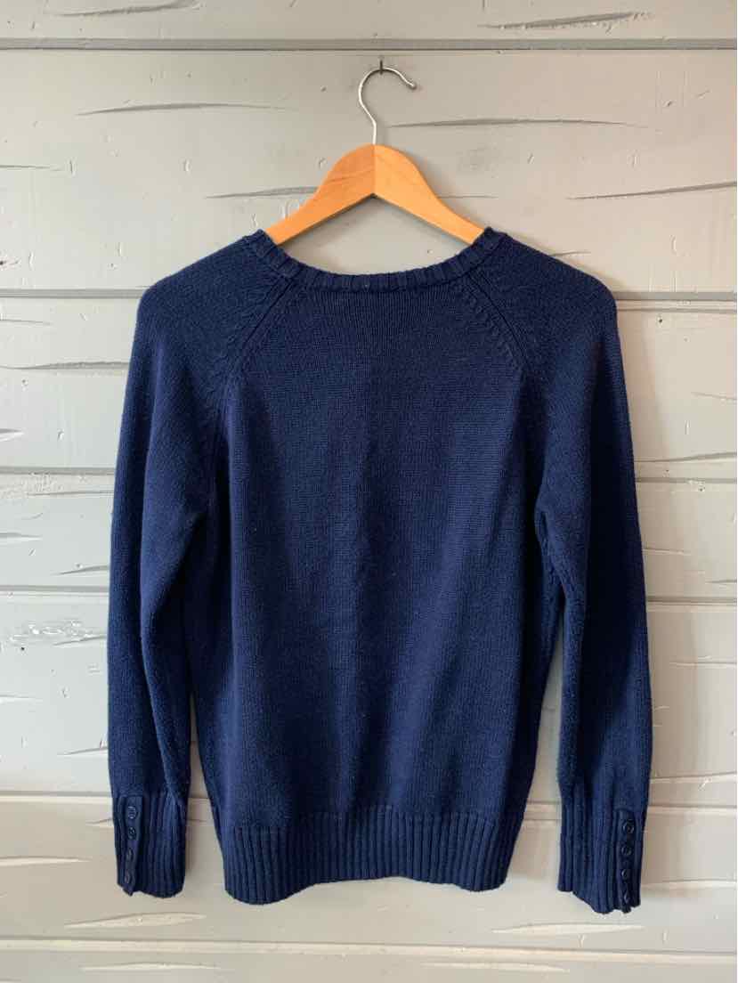 Navy blue long-sleeve knit sweater with ribbed cuffs and hem hanging on wooden hanger.