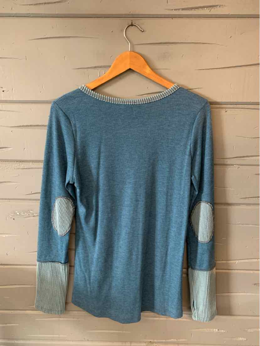 Blue long-sleeve shirt with light gray elbow patches and wide light gray cuffs on wooden hanger.