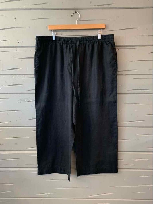 Black wide-leg linen pants with elastic waistband, size XL, hanging on wooden hanger.