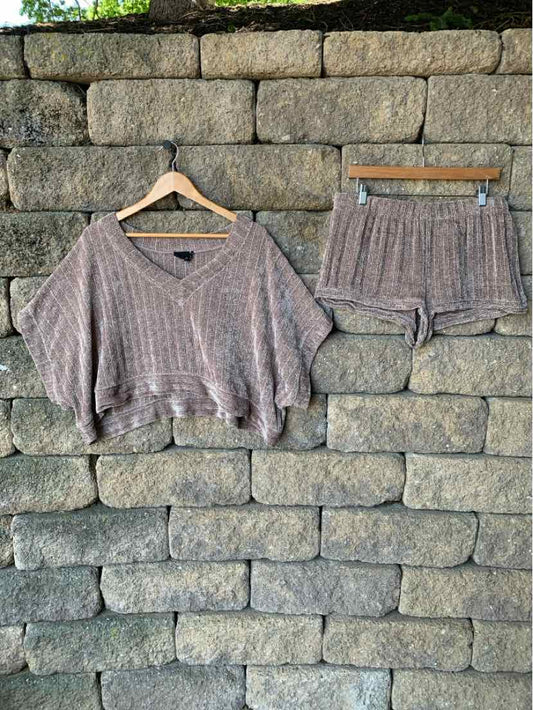 Brown chenille short-sleeve cropped top with matching loose shorts on wooden hangers against a stone wall.